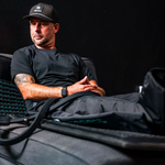 Man seated in RECON Elite compression boots on a RECON Renew PEMF mat