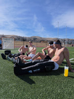 Athletes recovering in RECON Pro Compression Boots on the field