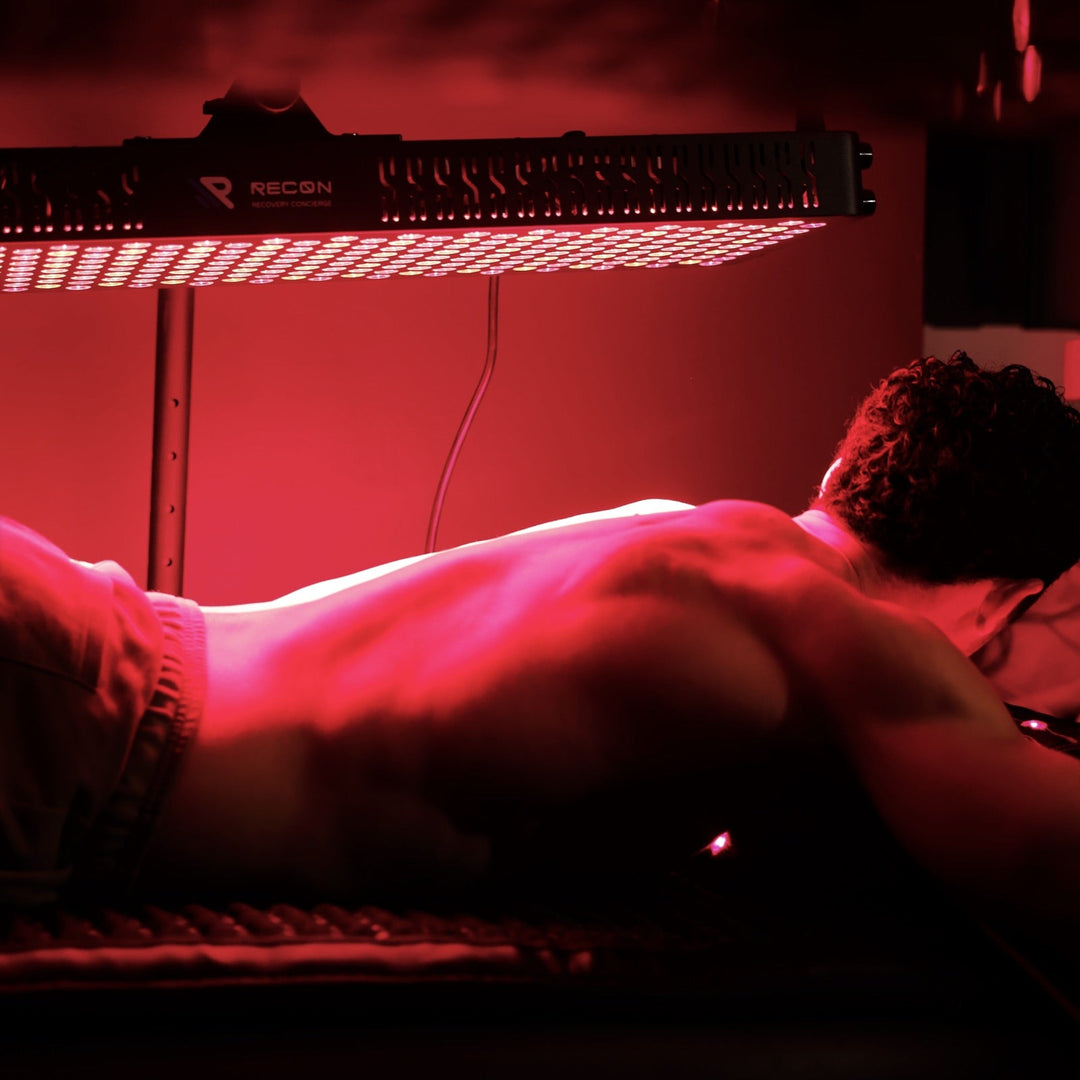 Person lying on a bed with a red light illuminating the scene