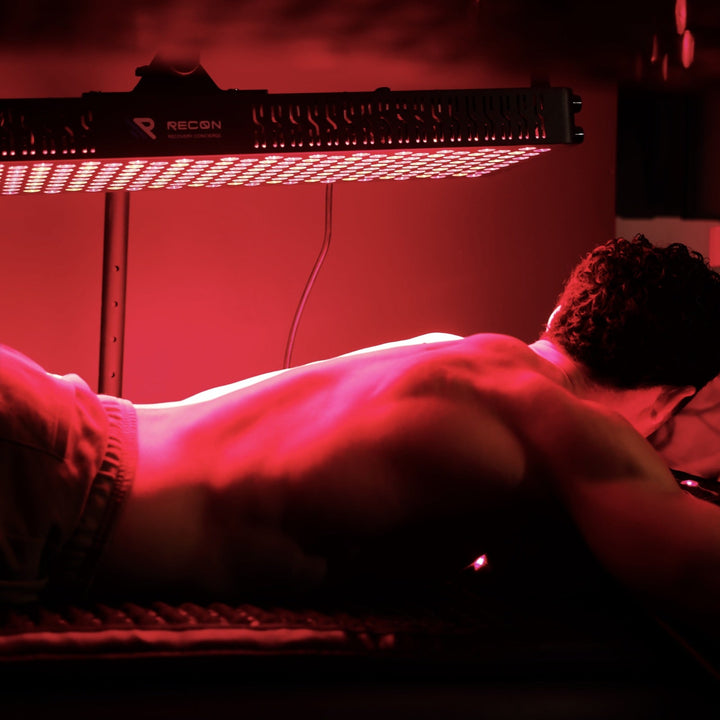 Person lying on a bed with a red light illuminating the scene